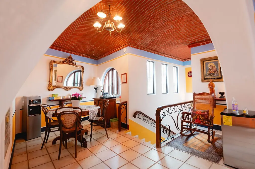 Breakfast room beneath a brick vault with chandelier and iron staircase