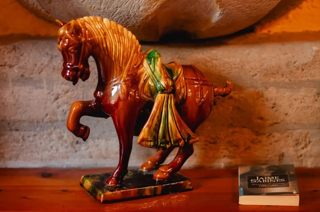 Glazed ceramic horse against a stone wall