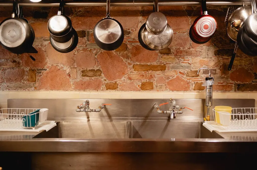Kitchen with copper pans over a stone wall