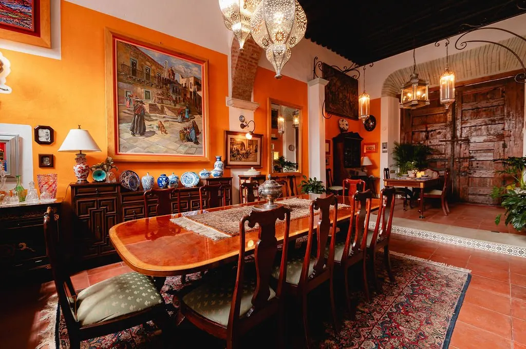 Dining room with a long mahogany table and orange walls