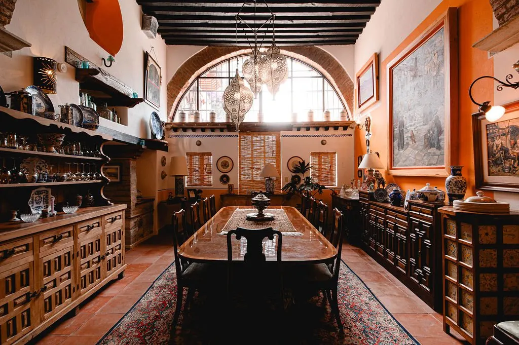 Grand dining room with arched window, carved sideboards and chandelier