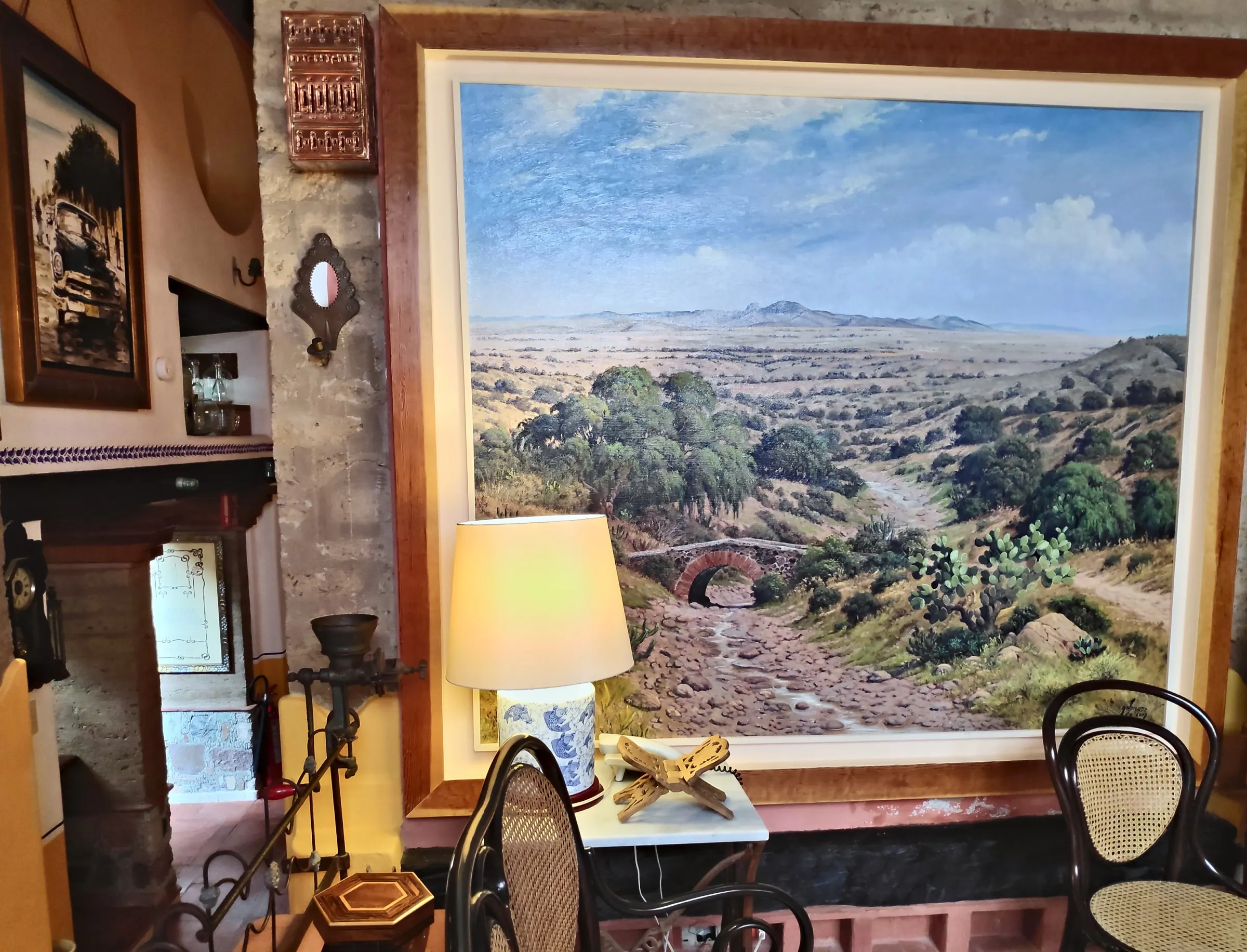 Study with a large painting of the Bajío landscape, a Talavera lamp and cane chairs