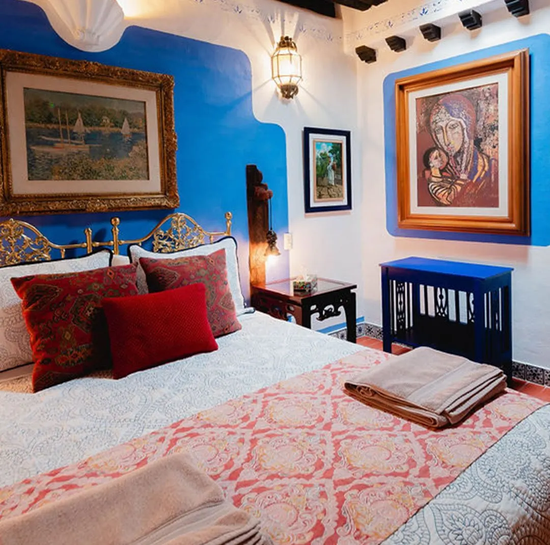 La Bufa suite with cobalt-blue walls, gilded wrought-iron headboard and artwork