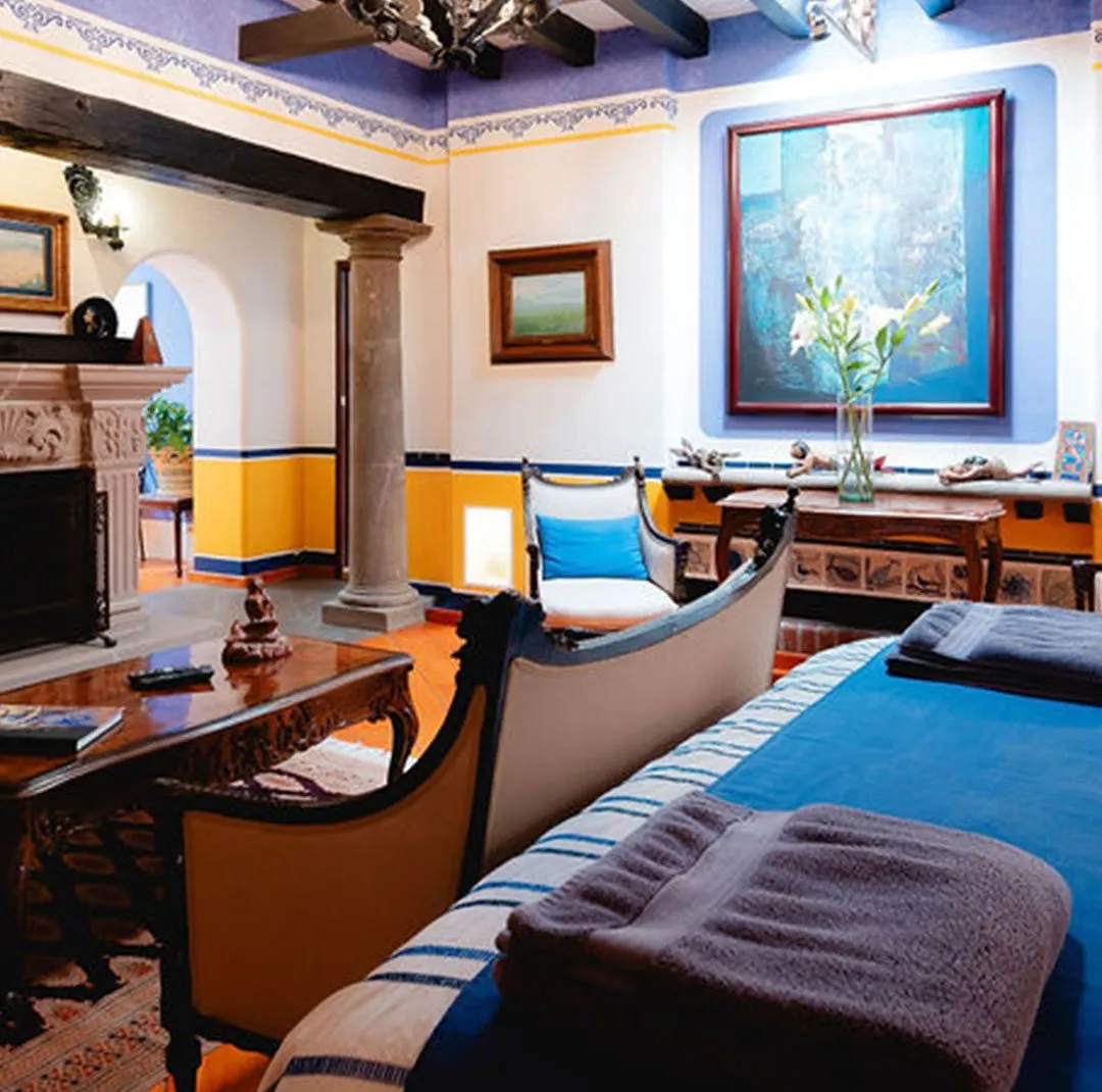 La Sirena suite with carved stone fireplace, stone column and blue bedspread