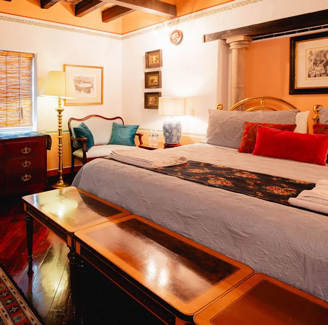 Los Picachos suite with period loveseat, wooden beams and garnet cushions