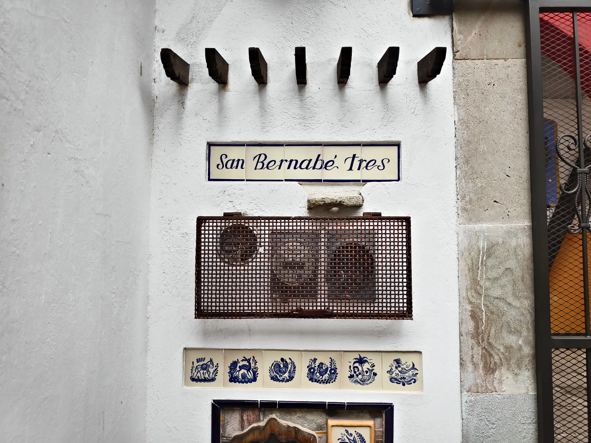 Tiled «Sanbernabé Tres» sign on the white wall at the entrance