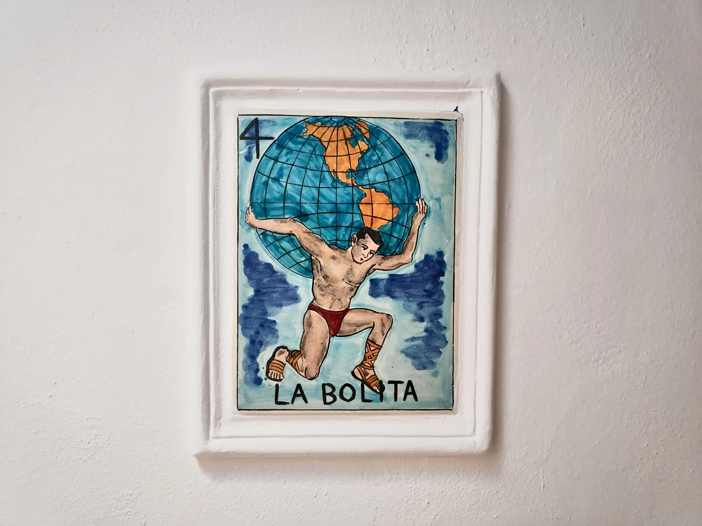 Lotería tile number 4, La Bolita, on the wall beside the suite door