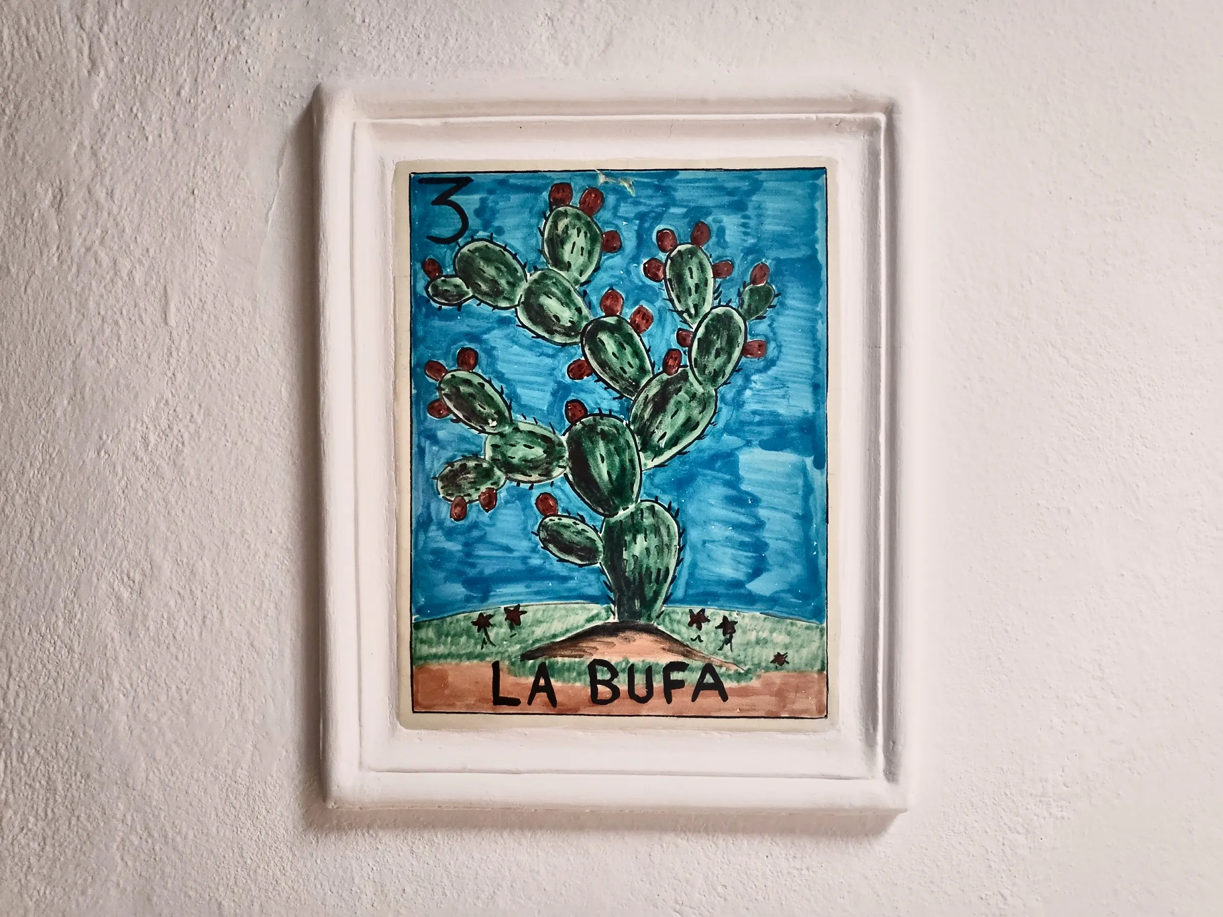 Lotería tile number 3, La Bufa, on the wall beside the suite door