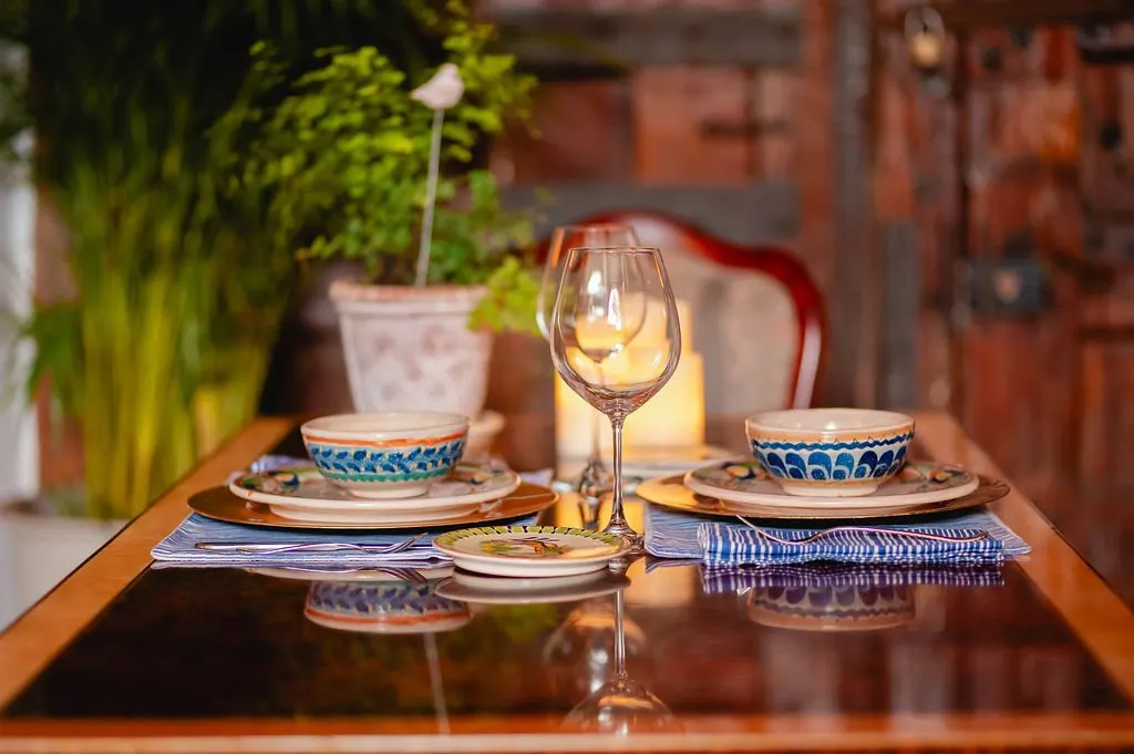 Breakfast table set with blue pottery and a crystal glass