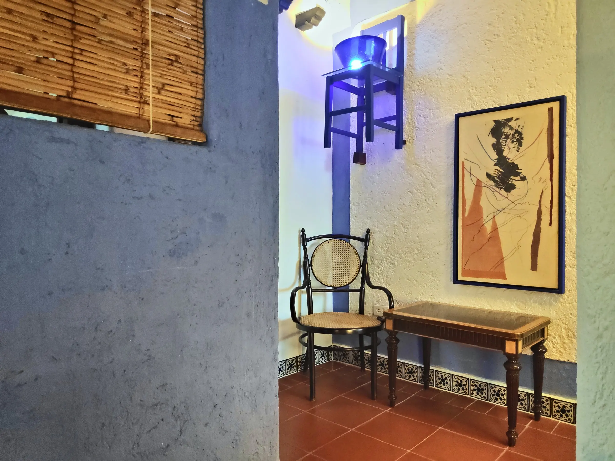 Writing corner in the La Bufa suite, with a cane chair and framed artwork