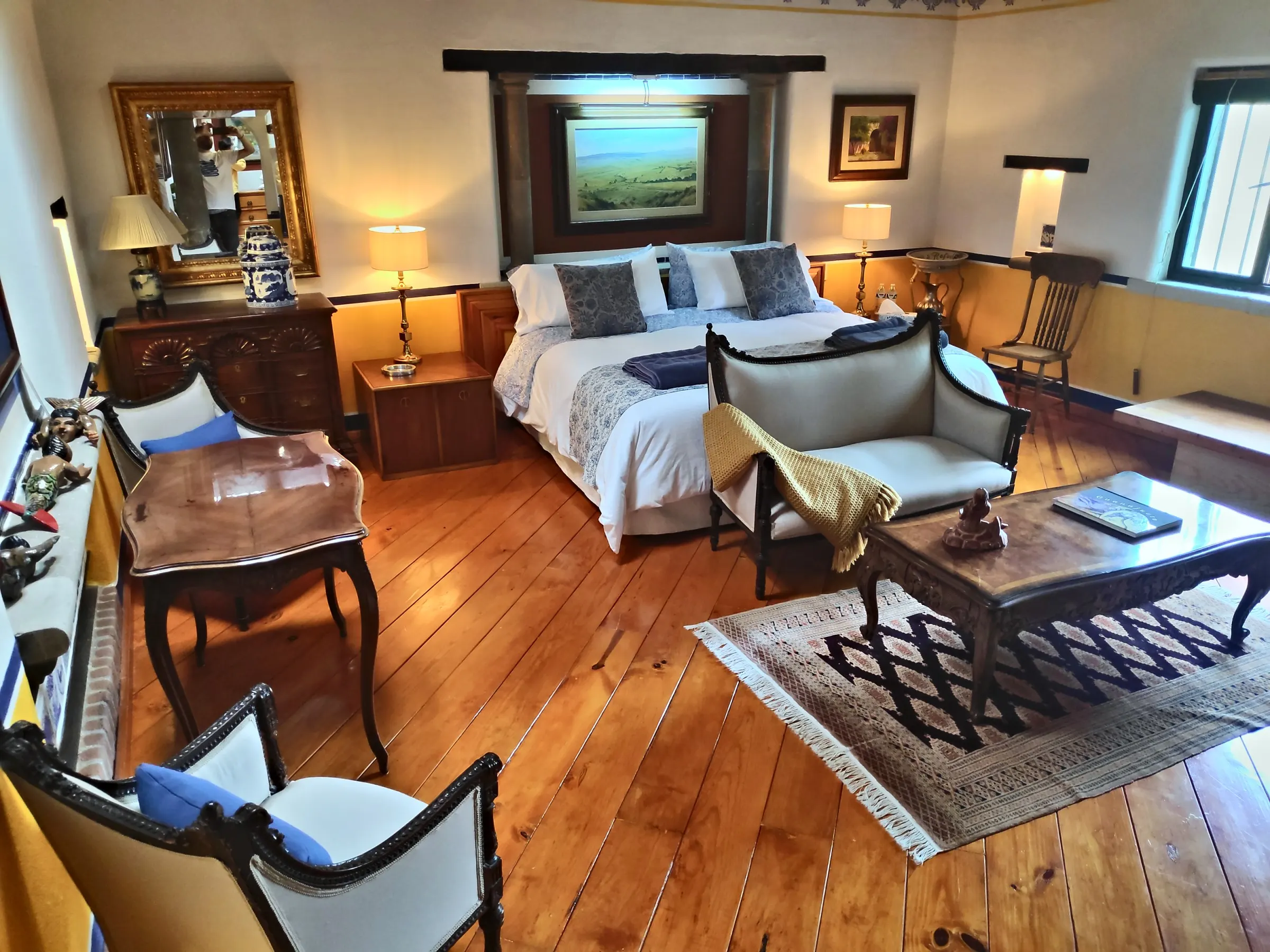 Sitting area of the La Sirena suite with a period settee, coffee table and wooden floor